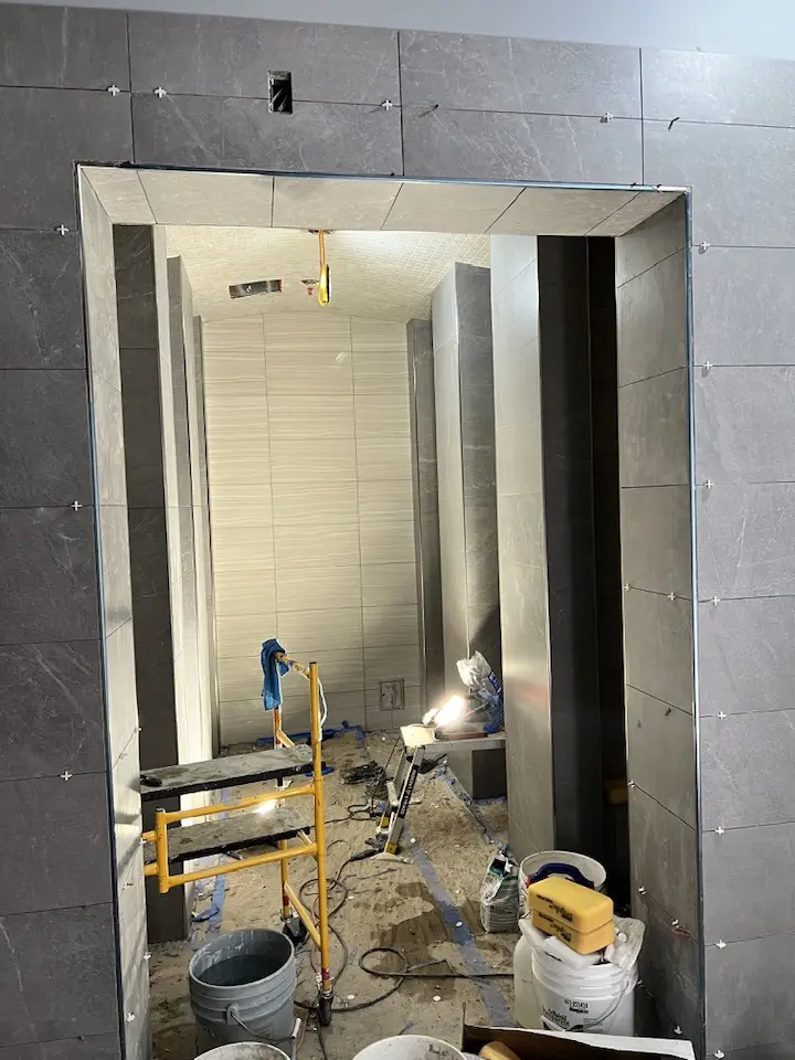 Work in progress: Shower stalls being tiled with ceramic tiles.