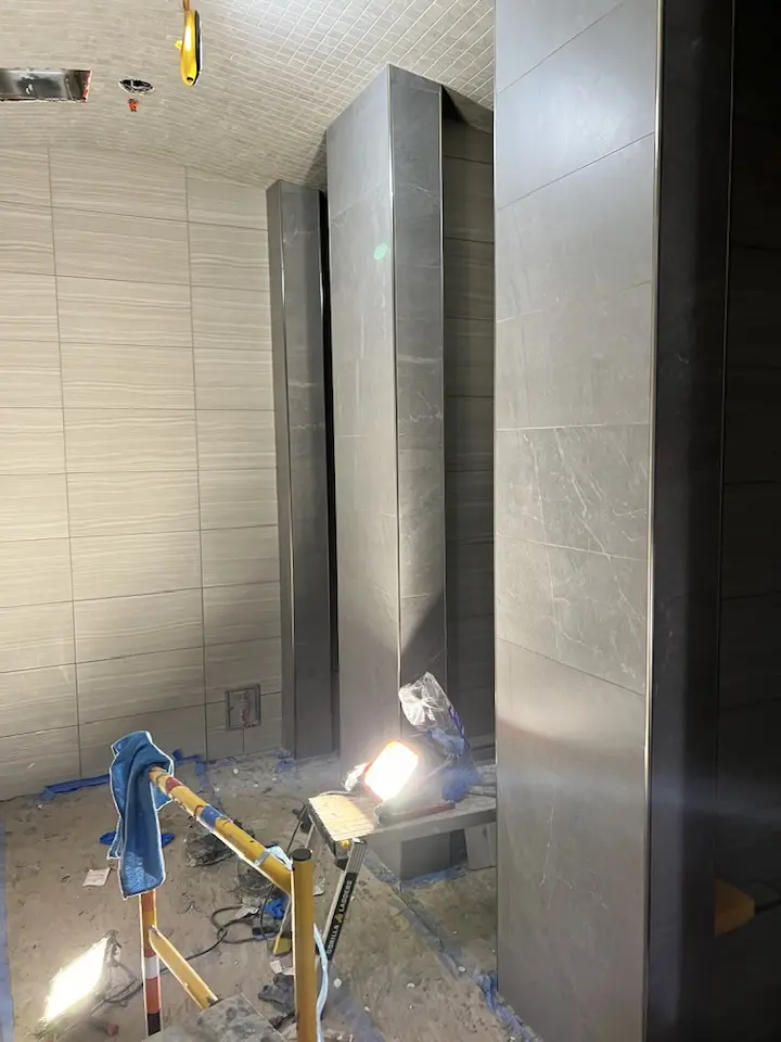 Shower stalls with completed wall tile work, showcasing intricate design.